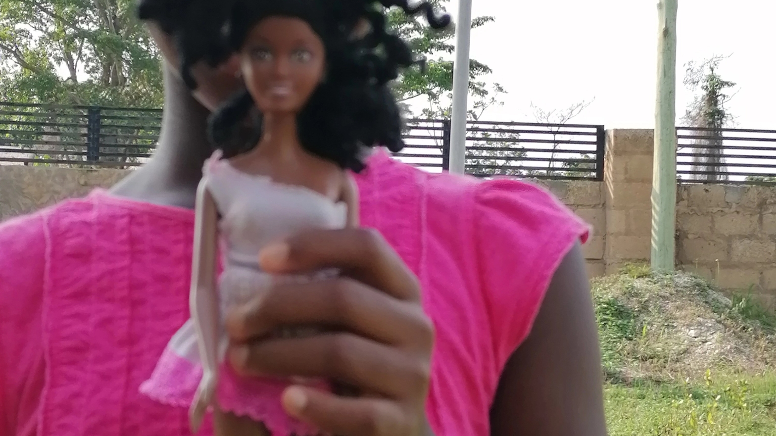 Girl holding her little black doll